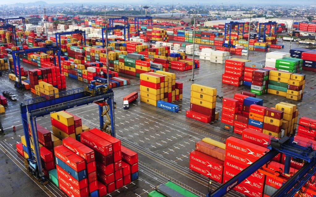 Porto movimentado com containers e lupa, ilustrando a fiscalização de importações.