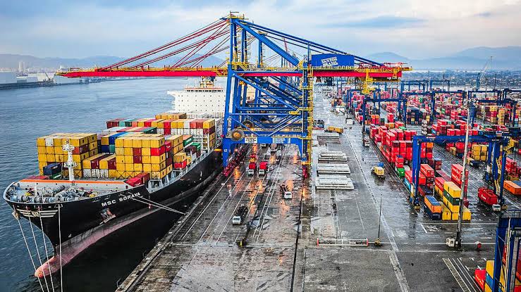 Navio cargueiro transportando granéis em um porto, com a interface do Portal Único de Comércio Exterior em destaque. 2